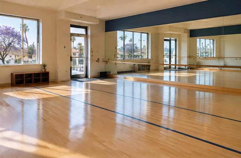 Illustration: a Torrance dance studio with a pale maple floor, a mirror wall and a barre, a floor with painted lines drying near the entry